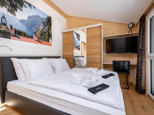 een slaapkamer met een groot wit bed en een tv bij Haus Estelle in Sankt Lorenzen ob Murau