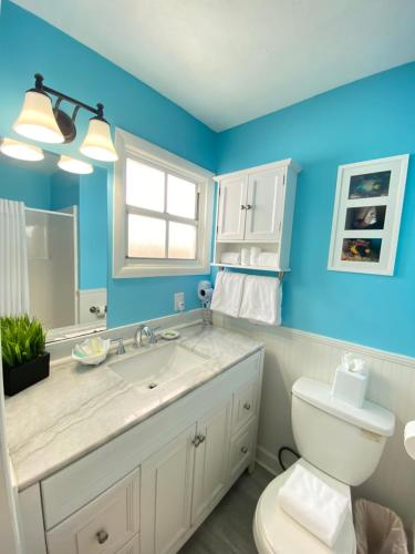 a bathroom with blue walls and a toilet and a sink at The Palms Hotel in Key West