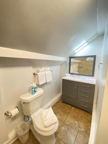 a bathroom with a white toilet and a sink at The Palms Hotel in Key West