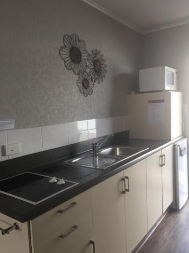 a kitchen with a sink and a microwave at Lakefront Lodge in Te Anau