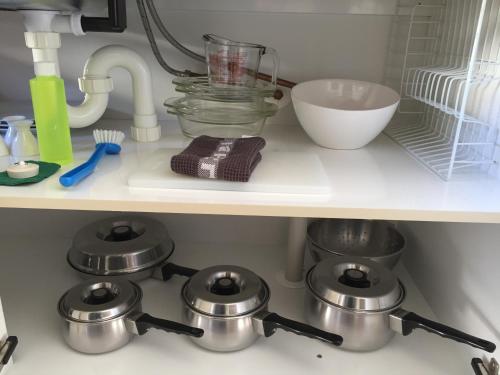 a kitchen counter with pots and pans on a shelf at Lakefront Lodge in Te Anau