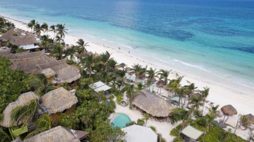 an aerial view of a beach with huts and the ocean at Sueños Tulum in Tulum