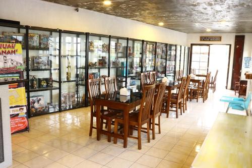 a dining room with a table and chairs and books at Hotel Griya Wijaya in Ambarawa