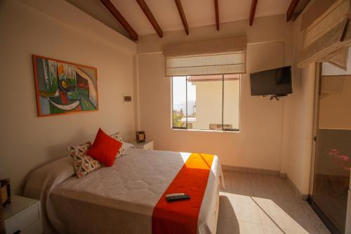 a bedroom with a bed and a television in it at Matices del Mar en Canoas in Canoas De Punta Sal