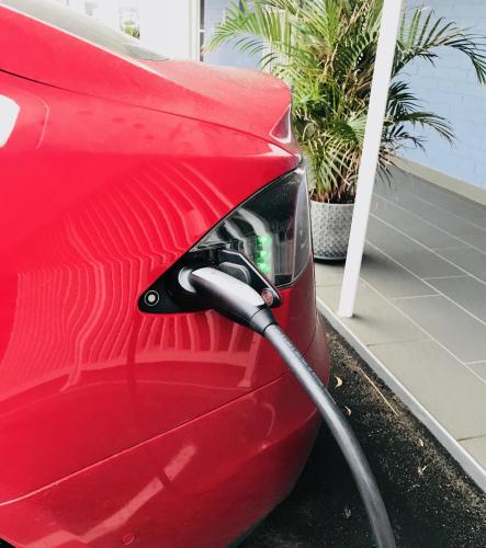 a red car with a hose hooked up to it at Harbour View Apartments in Ulladulla