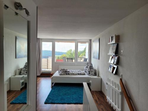 a bedroom with a bed and a large window at Ferienwohnung Bergpanorama mit Pool in Sankt Englmar