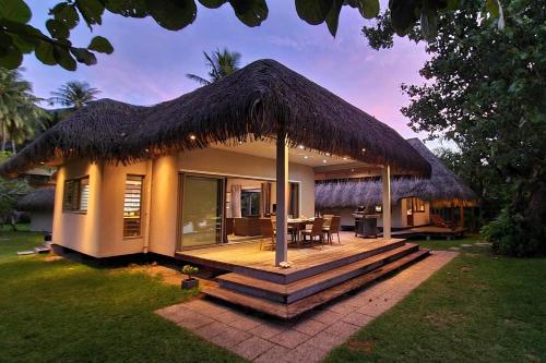a small house with a grass roof at Villa Meheana in Moorea