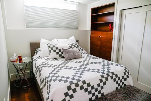 a bedroom with a bed with a black and white comforter at Studio on Capri in Calgary