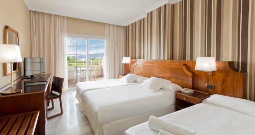 a hotel room with two beds and a television at Elba Motril Beach & Business Hotel in Motril