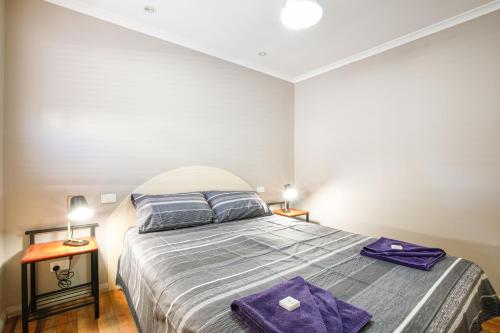 a bedroom with a bed with purple towels on it at Kalbarri Tudor Holiday Park in Kalbarri