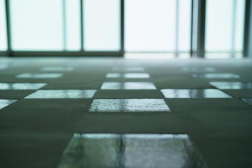 an empty room with windows and a checkered floor at Seven Stories in Nagoya