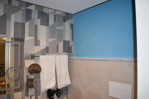 a bathroom with white towels and a shower at Federico 70 Rubino Family in Palermo