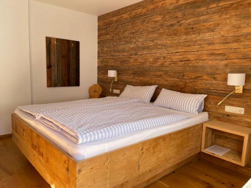 a bed in a room with a wooden wall at HAUS ERIKA apartments in Sölden