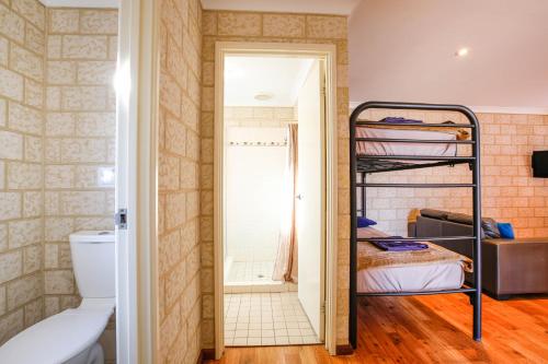 a small room with a bunk bed and a bathroom at Kalbarri Tudor Holiday Park in Kalbarri