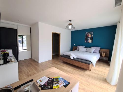 La suite de la route des chateaux في Arsac: غرفة نوم بسرير وجدار ازرق