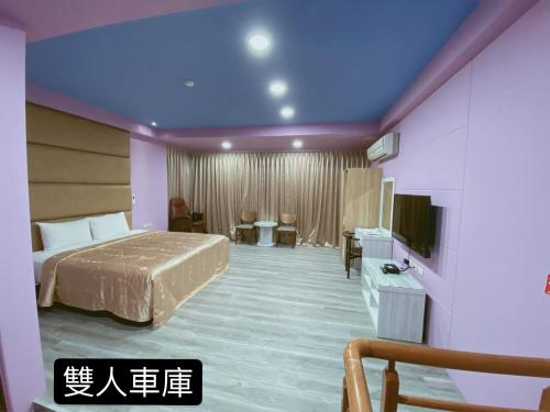 a hotel room with a bed and a flat screen tv at 溫沙堡汽車旅館 Windsor Castle Garden Motel in Jiaoxi