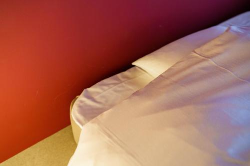 a close up of a white tie on a bed at Seven Stories in Nagoya