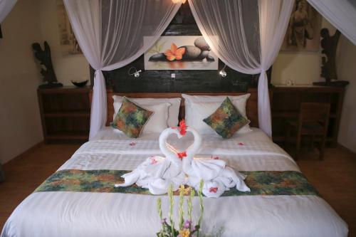 two swans made out of towels on a bed at KTS Balinese Villas in Canggu