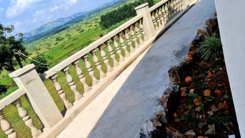 a staircase leading down to a road with mountains in the background at GKAT Resort in Mbarara