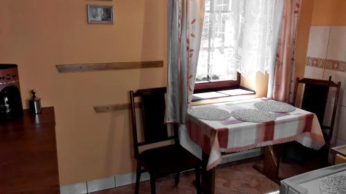 a small table and a chair in a room with a window at Dom Pod Jaśminem in Ustrzyki Dolne