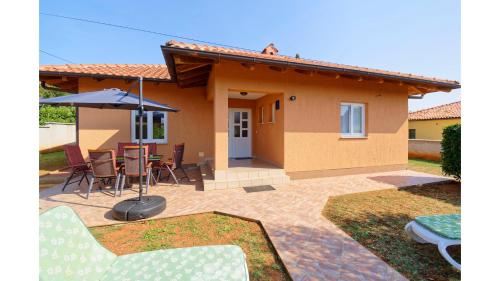 a house with a patio and a table with an umbrella at Holiday Home Tina in Savudrija