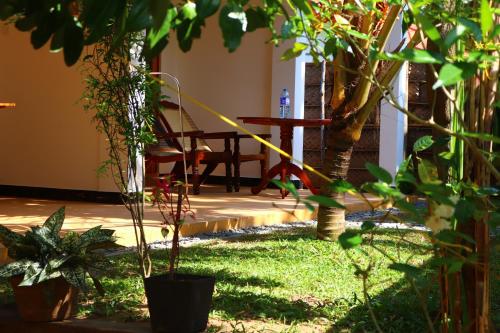 a garden with a table and chairs and plants at Relax Beach House in Tangalle
