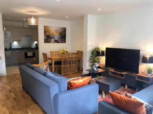 Sala de estar con 2 sofás azules y TV en FW Haute Apartments at Queensbury, Ground Floor 2 Bedrooms and 2 Bathrooms with King or Twin beds with Front Porch and FREE WIFI and FREE PARKING en Wealdstone