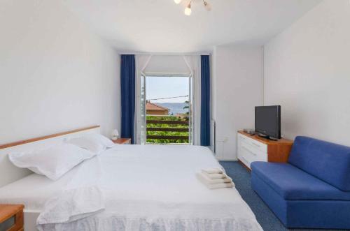 - une chambre avec un lit et une chaise bleue dans l'établissement Apartment in Novi Vinodolski 15312, à Novi Vinodolski