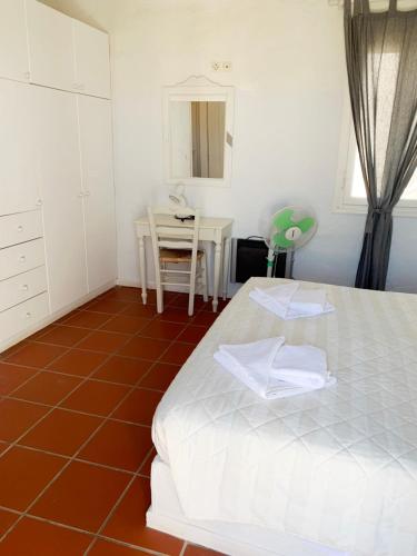a bedroom with a bed and a table and chairs at Anezina Village in Drios