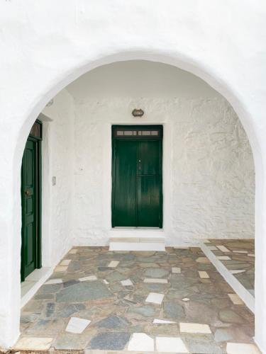an archway with two green doors in a white building at Anezina Village in Drios