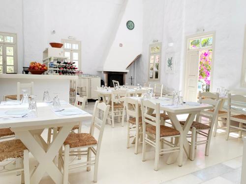 a dining room with white tables and chairs at Anezina Village in Drios