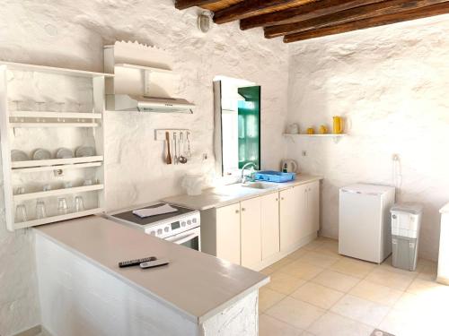 a white kitchen with a sink and a stove at Anezina Village in Drios