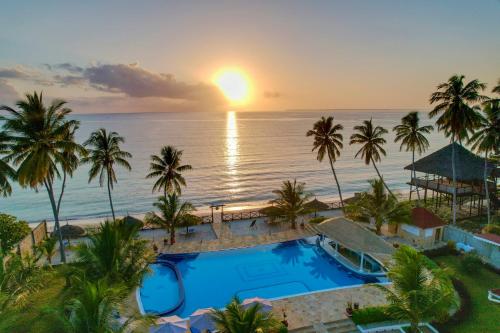an aerial view of a resort with a pool and the ocean at Sunny Palms Beach Bungalows in Uroa
