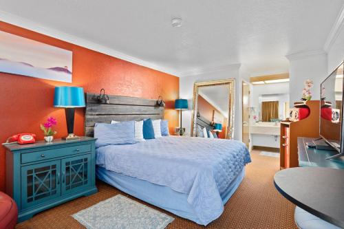 a bedroom with a bed and an orange wall at Americana Inn Motel in South San Francisco