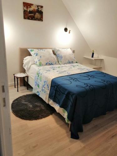 une chambre avec un lit avec une couette bleue dans l'établissement Chambres d'Hôtes Chez Marilou, à Aulnay-sous-Bois