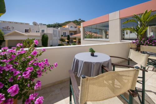 a table and chairs on a balcony with flowers at Toxo Hotel in Plataniás