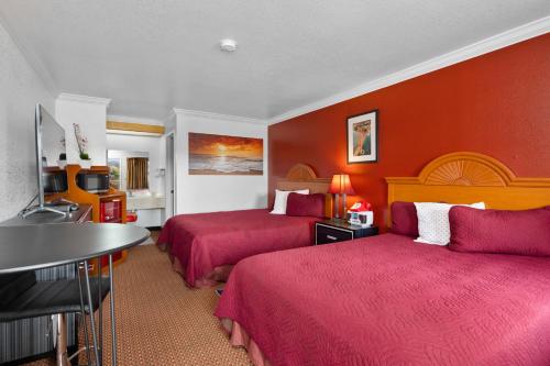 a hotel room with two beds with red walls at Americana Inn Motel in South San Francisco