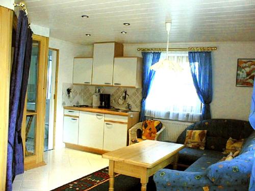 eine Küche und ein Wohnzimmer mit einem Tisch und einem Sofa in der Unterkunft Ferienwohnung Held in Waging am See