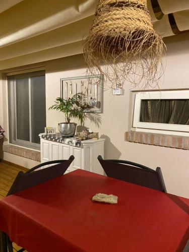una sala da pranzo con tavolo e sedie rossi di Ancora bilocale a Marina di Massa