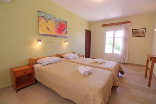 a bedroom with two beds with towels on them at House Dimitri Agios Georgios Pagoi Corfu in Agios Georgios Pagon