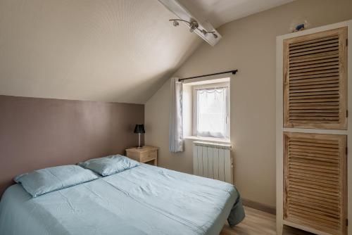 um quarto com uma cama azul e uma janela em Joli appartement - 4min à pieds de la plage em Asnelles