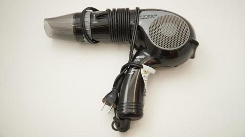 a blow dryer and a microphone on a wall at New Normal Hotel in MATSUYAMA ニューノーマルホテルイン松山 in Naha