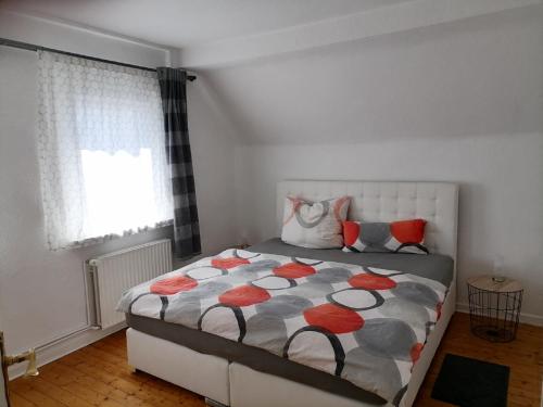 een slaapkamer met een bed met rode en oranje kussens bij Ferienwohnnung Herling in Siegen