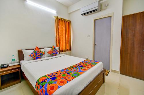 um quarto com uma cama grande e um cobertor colorido em FabExpress P.A.S Residency em Chennai