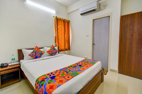 a bedroom with a large bed with a colorful blanket at FabExpress P.A.S Residency in Chennai