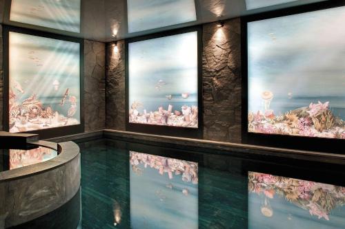 a room with a large aquarium with fish in it at La Demeure Montaigne in Paris