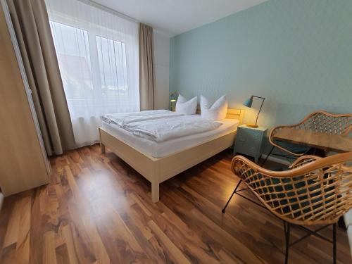 a bedroom with a bed and a desk and a window at Haus Achtern Diek in erster Reihe am Meer in Fehmarn