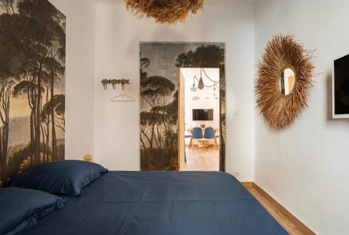 a bedroom with a blue bed and a mirror at Appartement le Quai du Port Cassis parking clim in Cassis