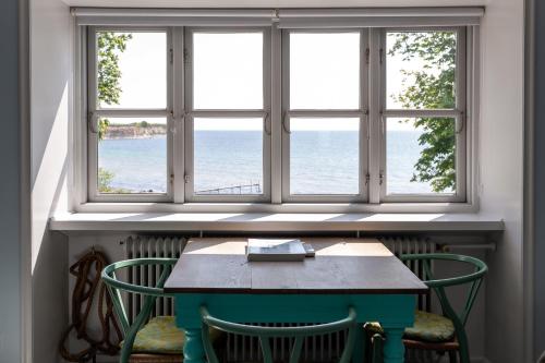a table and chairs in front of a window at Rødvig Kro og Badehotel in Rødvig