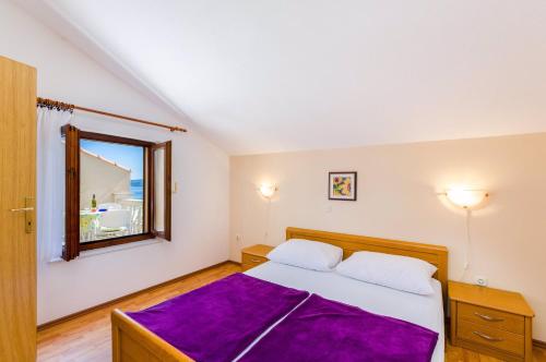 a bedroom with a bed with a purple blanket at Two-Bedroom Apartment Crikvenica 19 in Dramalj